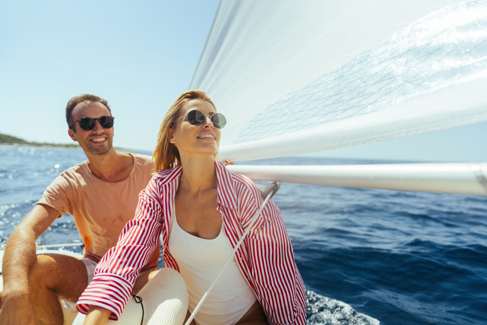 Couple enjoying a summer day on a small sailboat